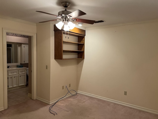 interior space featuring ceiling fan, light colored carpet, ornamental molding, and sink