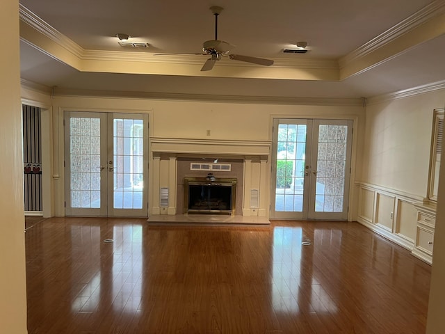 unfurnished living room featuring ceiling fan, french doors, ornamental molding, and hardwood / wood-style flooring