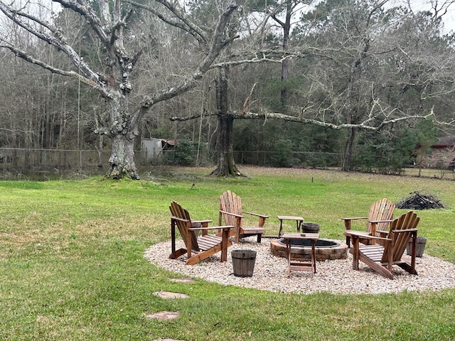 view of yard with fence and a fire pit