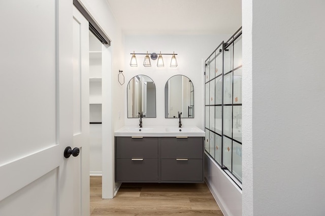 bathroom with vanity, wood-type flooring, and combined bath / shower with glass door