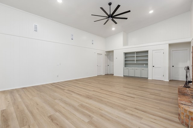 unfurnished living room with ceiling fan, built in shelves, high vaulted ceiling, and light hardwood / wood-style flooring