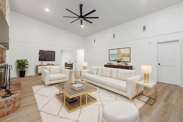 living room featuring ceiling fan, high vaulted ceiling, and light hardwood / wood-style floors