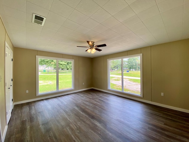 spare room with ceiling fan, dark hardwood / wood-style flooring, and a healthy amount of sunlight