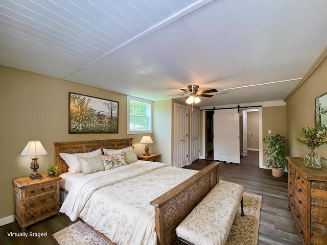 122 Otteson Ln, Lufkin, TX 75901 - bedroom featuring a barn door, dark wood-style flooring, a ceiling fan, and wood ceiling