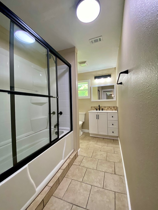 full bathroom featuring tile patterned flooring, vanity, bath / shower combo with glass door, and toilet