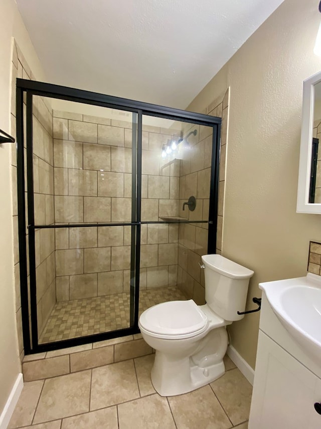 bathroom featuring tile patterned flooring, vanity, toilet, and walk in shower