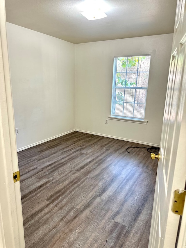 spare room with dark hardwood / wood-style floors