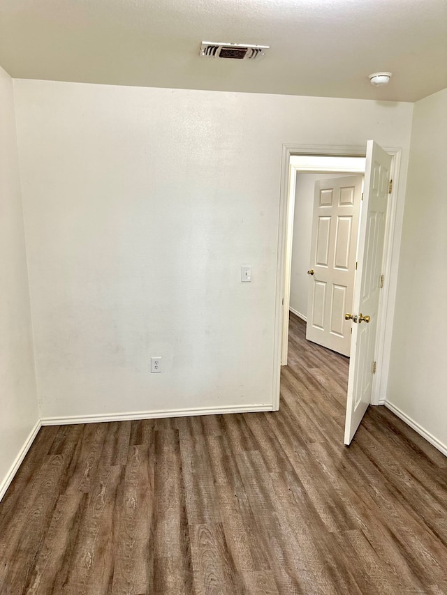 empty room featuring dark wood-type flooring