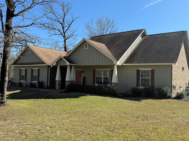 craftsman-style home with a front yard, board and batten siding, stone siding, and a shingled roof