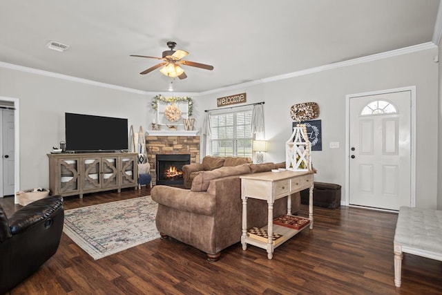 living area with visible vents, crown molding, ceiling fan, a fireplace, and wood finished floors