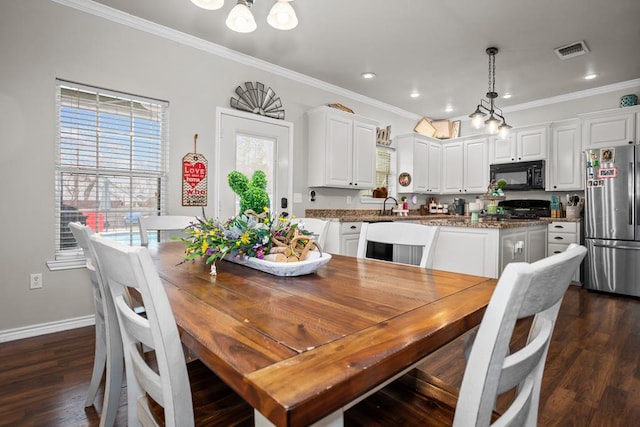 dining area featuring visible vents, dark wood-style flooring, baseboards, and ornamental molding