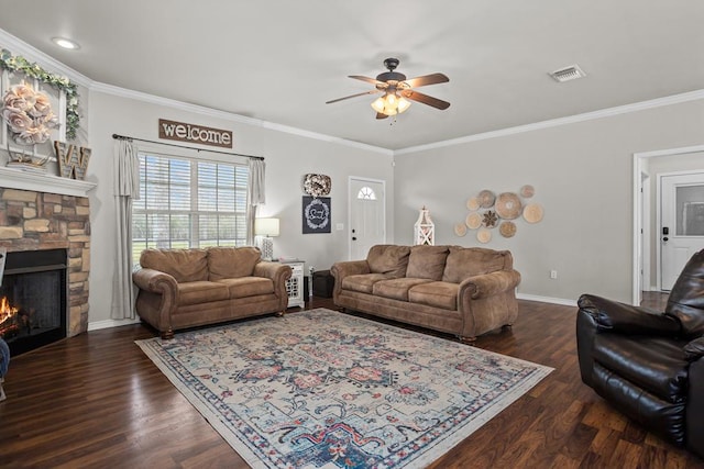 living room featuring a stone fireplace, dark wood finished floors, visible vents, and ornamental molding