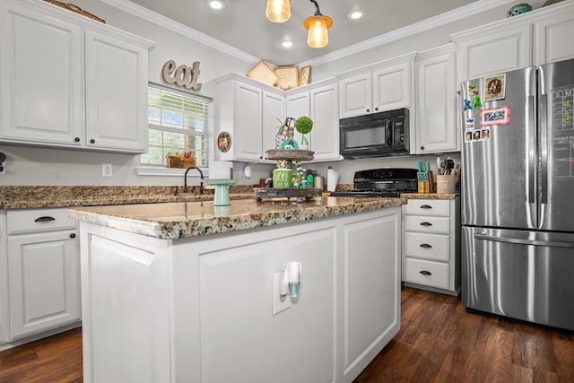 kitchen featuring ornamental molding, a kitchen island, freestanding refrigerator, black microwave, and range