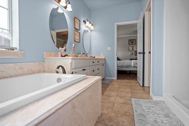 bathroom featuring tile patterned floors, ensuite bathroom, baseboards, a bath, and vanity