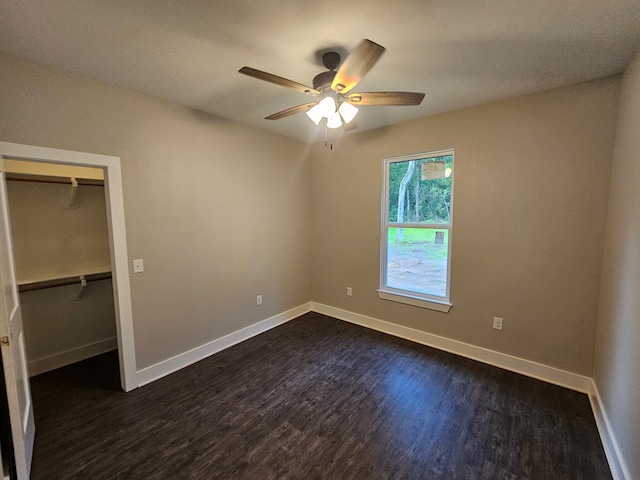 317 Shirey Ln, Lufkin, TX 75901 - unfurnished bedroom featuring a ceiling fan, a closet, a spacious closet, dark wood finished floors, and baseboards