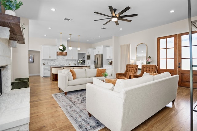 217 Derek Rd, Lufkin, TX 75904 - living area with ceiling fan, a stone fireplace, light wood-style flooring, and recessed lighting