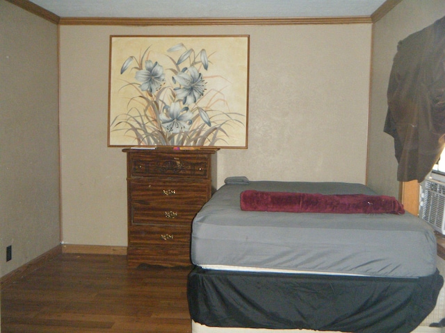 bedroom with hardwood / wood-style flooring and crown molding