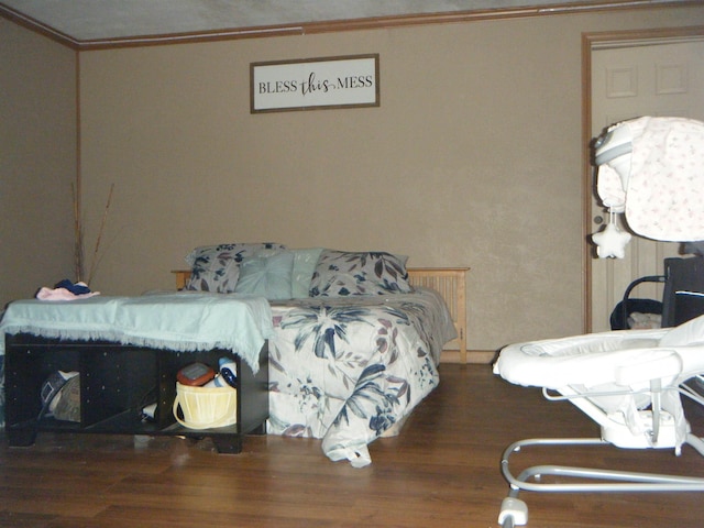 bedroom with crown molding and dark wood-type flooring