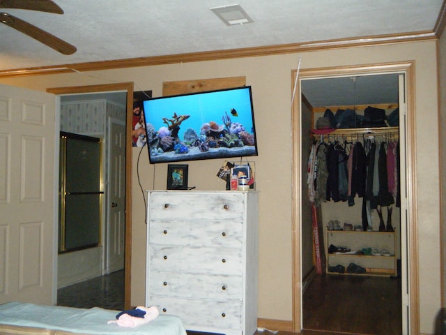 bedroom with ceiling fan, a closet, and ornamental molding