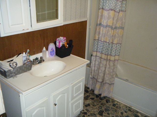 bathroom featuring shower / bath combination with curtain, wood walls, and vanity