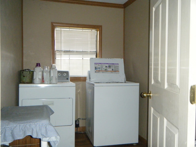 washroom featuring dark hardwood / wood-style floors, ornamental molding, and washing machine and clothes dryer