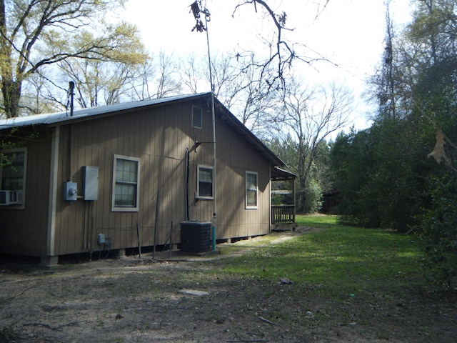 view of side of home with a yard and central AC unit