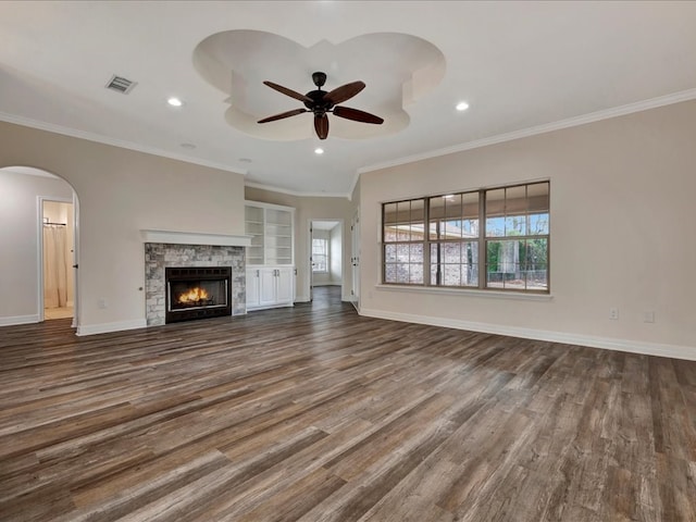 unfurnished living room with ornamental molding, wood-type flooring, and a wealth of natural light