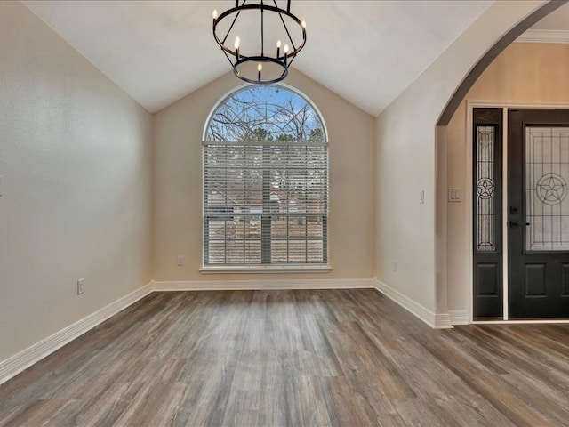 foyer entrance featuring hardwood / wood-style flooring, lofted ceiling, and an inviting chandelier