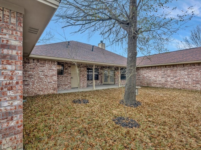 rear view of property featuring a yard and a patio