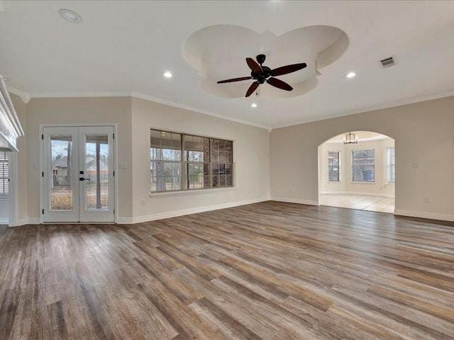 unfurnished living room with ornamental molding, light hardwood / wood-style flooring, ceiling fan, and french doors