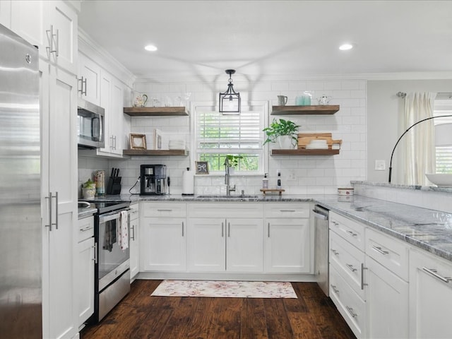 kitchen featuring crown molding, open shelves, tasteful backsplash, a sink, and stainless steel appliances