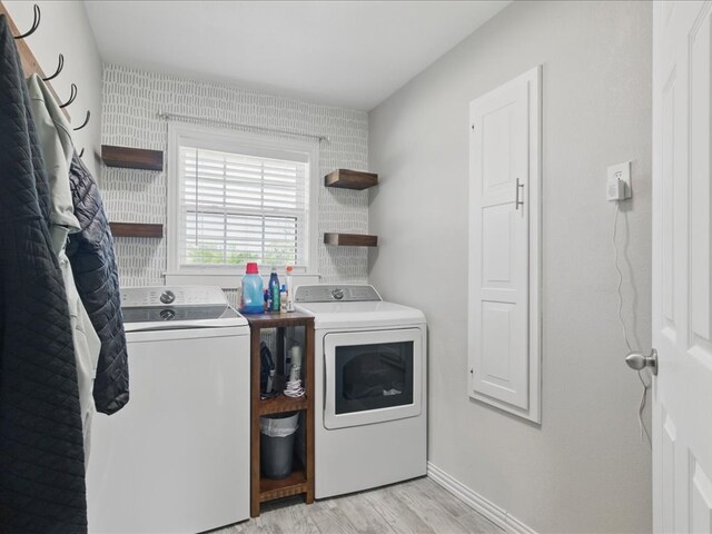 clothes washing area with independent washer and dryer, light wood-style floors, baseboards, and laundry area