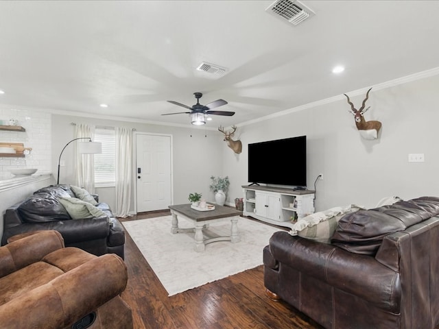 living area featuring wood finished floors, visible vents, and crown molding
