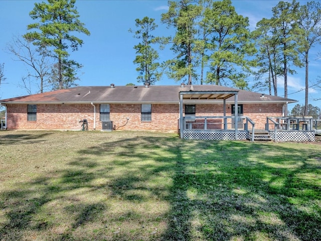 back of house with a yard, central air condition unit, brick siding, and a wooden deck