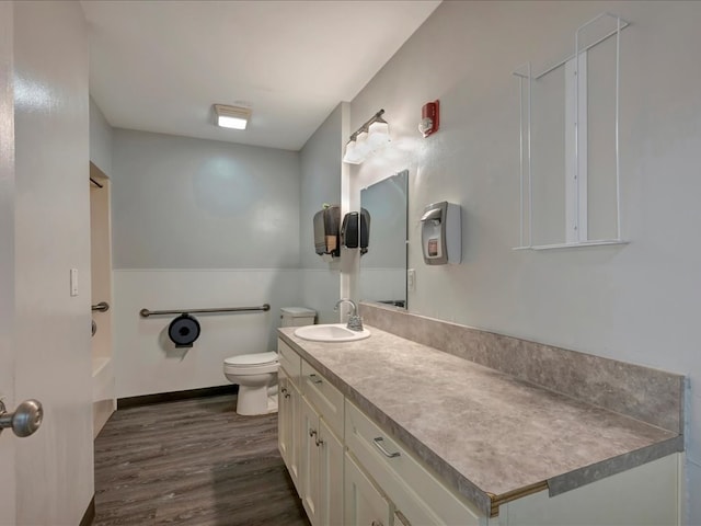 full bath featuring baseboards, toilet, wood finished floors, and vanity