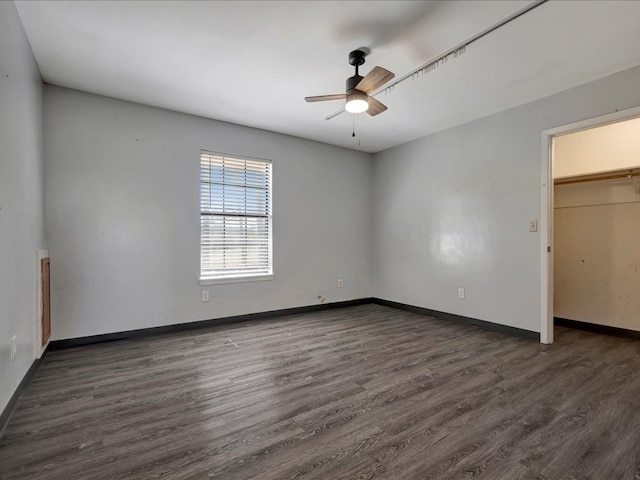 unfurnished bedroom featuring a closet, a ceiling fan, baseboards, and wood finished floors