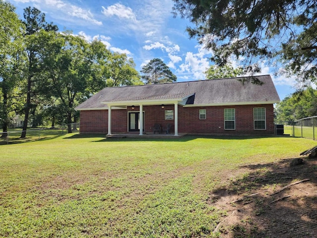 rear view of property with a lawn and a patio area