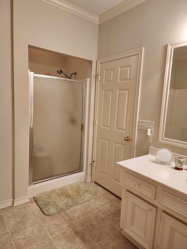 bathroom featuring tile patterned flooring, ornamental molding, vanity, and a shower with shower door