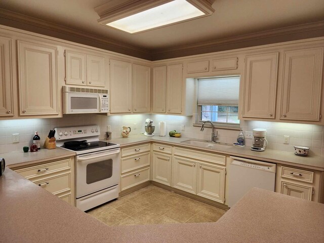 kitchen with crown molding, sink, light tile patterned flooring, and white appliances