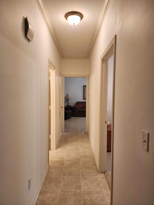 corridor featuring light tile patterned floors and crown molding