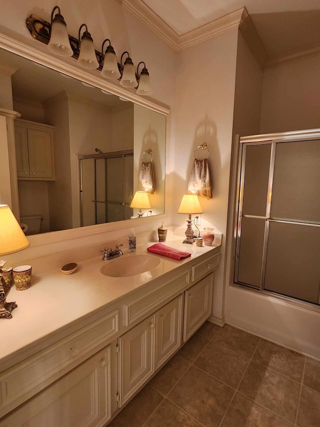 full bathroom with ornamental molding, bath / shower combo with glass door, vanity, tile patterned flooring, and toilet