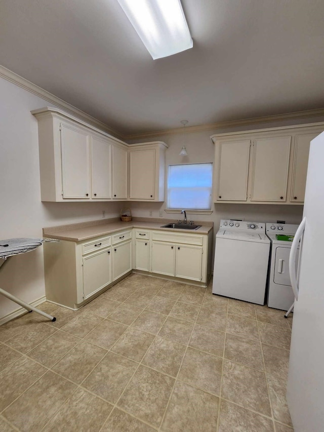 washroom with cabinets, ornamental molding, sink, light tile patterned floors, and washing machine and clothes dryer