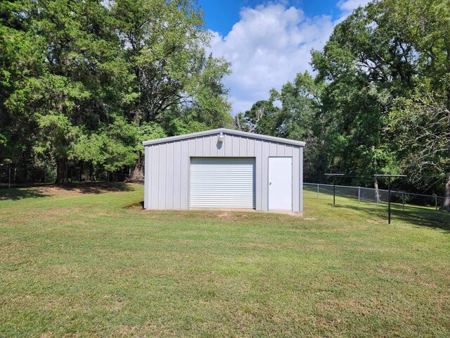 view of outdoor structure with a lawn and a garage