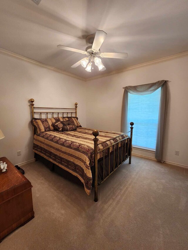 carpeted bedroom with ceiling fan and crown molding