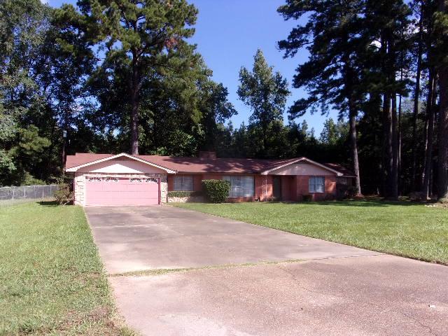 ranch-style home featuring a garage and a front lawn