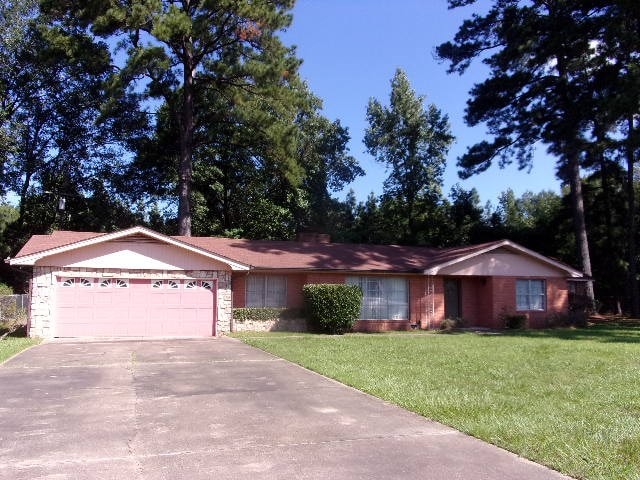 single story home with a front yard and a garage