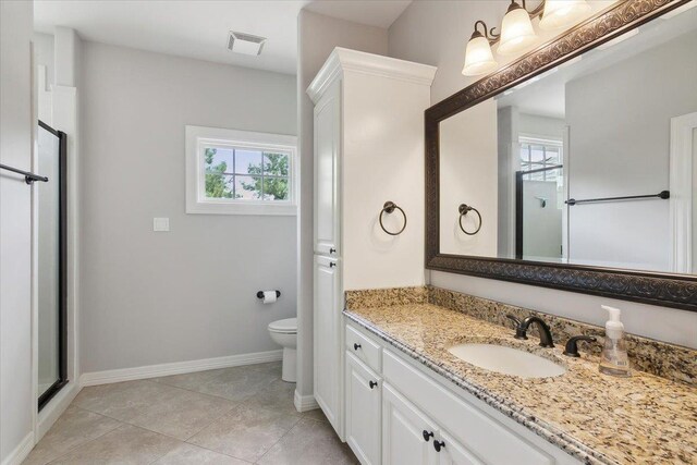 bathroom with tile patterned floors, vanity, toilet, and a healthy amount of sunlight