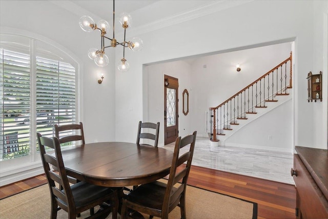 dining room featuring light hardwood / wood-style floors, crown molding, and a notable chandelier