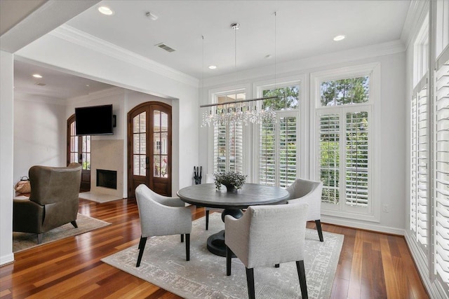 dining space featuring plenty of natural light, dark hardwood / wood-style floors, and ornamental molding