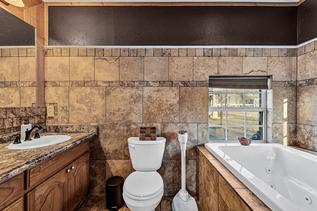 bathroom with tiled tub, vanity, tile walls, and toilet